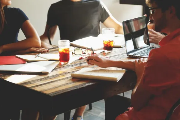 Small team discussing plans around a table with a laptop
