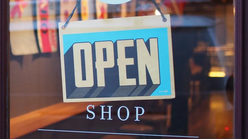 Open sign hanging in a shop window