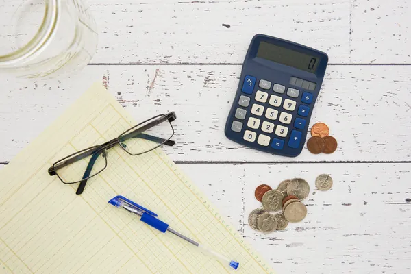 Calculator, coins and glasses on a desk
