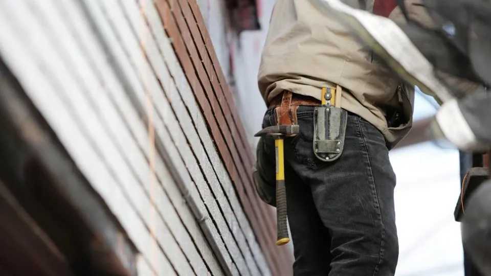 Tradesman with a tool belt working on site