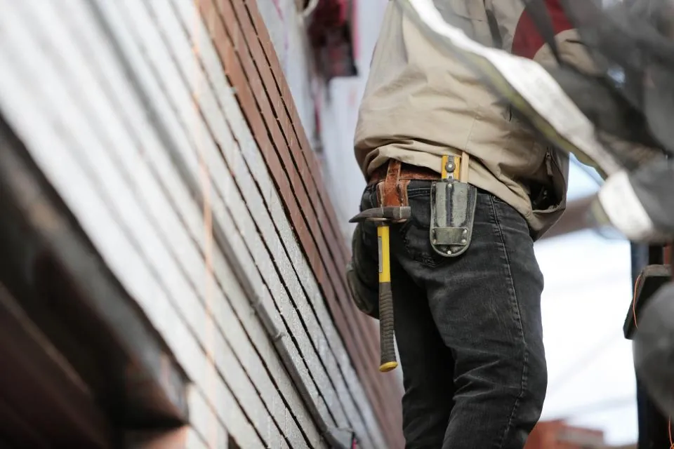 Builder on site wearing a tool belt