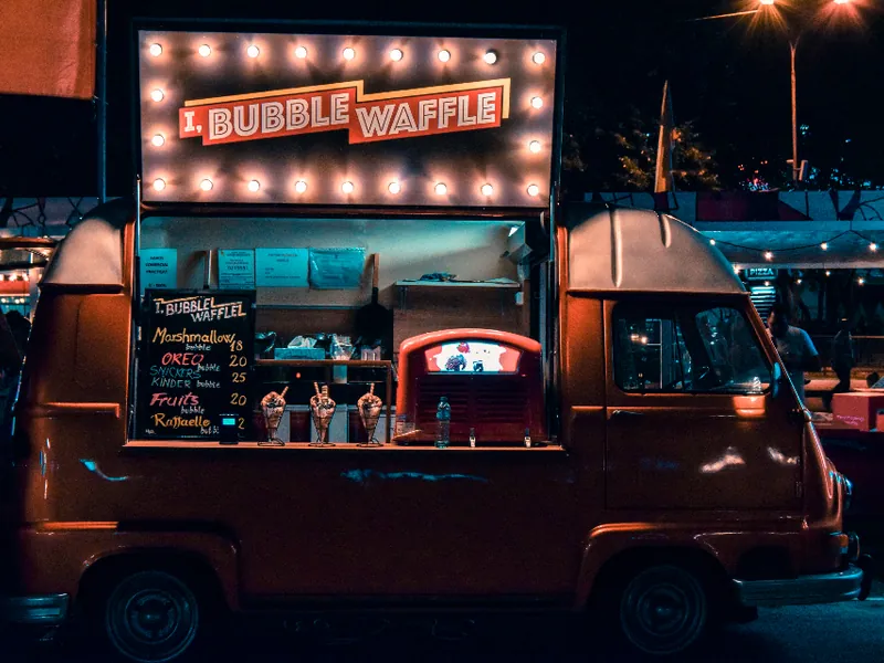Illuminated street food van at night