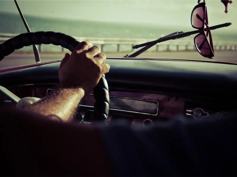 Hand on a steering wheel while driving