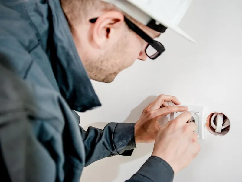 Electrician fitting a socket on a wall