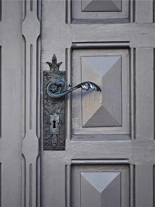 Grey panelled front door with a lever handle