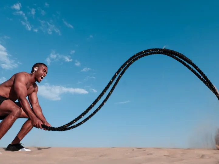 Athlete training with battle ropes outdoors