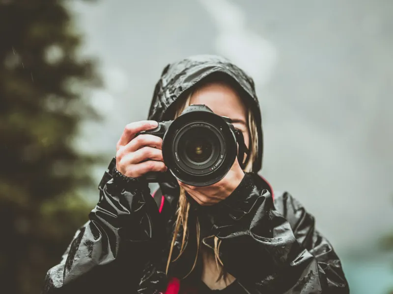 Photographer holding a camera up to their eye