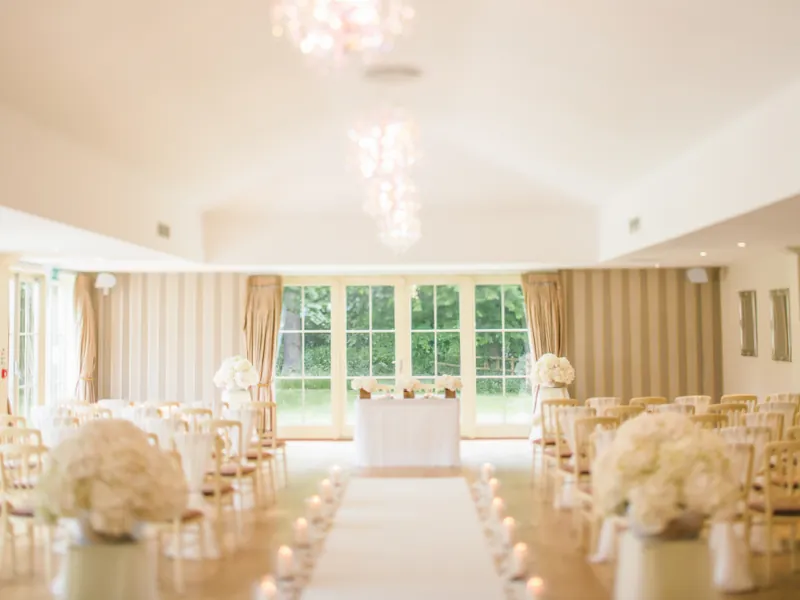 Ceremony room set with white chairs and floral aisle