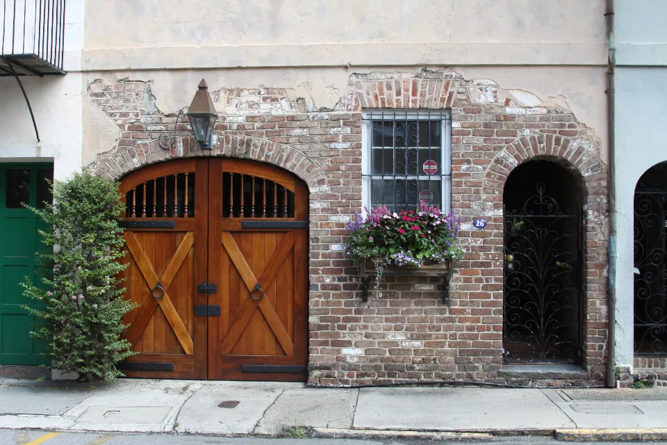 Brick building with wooden doors and windows with flower boxes